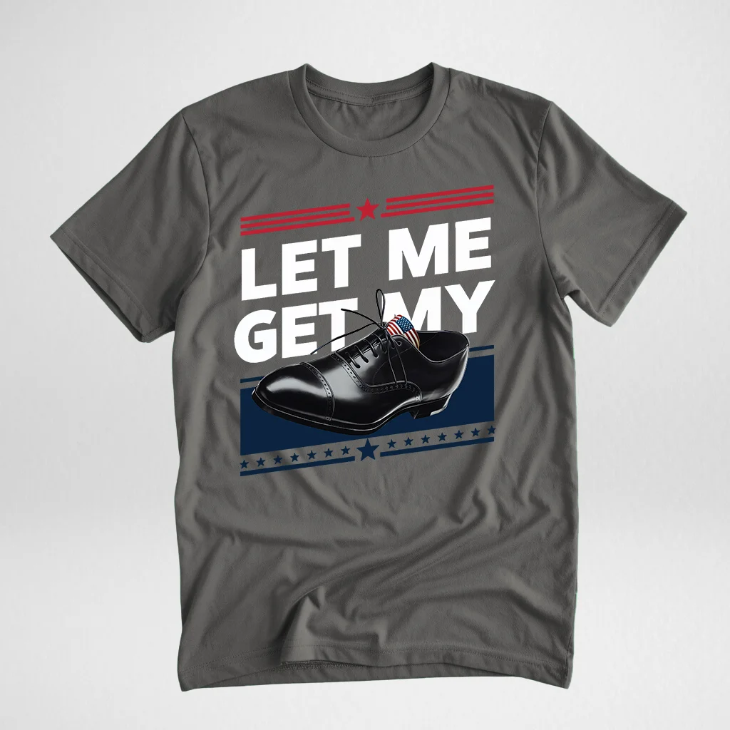 Gray t-shirt featuring a design with the text 'LET ME GET MY' alongside a black polished shoe illustration, displayed flat on a light surface.